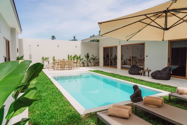 A swimming pool with a surrounding patio area, including seating and a covered section. - Stylish 3-bedroom villa with king suites near Lamai Beach (Chang Wat Surat Thani)