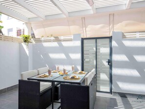 A sunlit patio with a table set for breakfast, including milkshakes and pastries, surrounded by wicker chairs. - Colina Hill Living4malaga (Torremolinos)