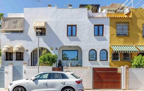 A white building with a garage door, a car parked in front, and a street lamp. - Colina Hill Living4malaga (Torremolinos)