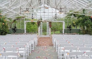 A covered outdoor venue with rows of white chairs, an exit sign, and floral decorations. - Spacious Family Friendly 3-bedroom home in a woodsy area of Ashland, NH (Ashland)