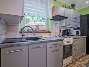 Eine moderne Küche mit Gasherd, Spüle und Mikrowelle.