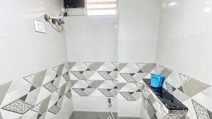 Un baño pequeño con inodoro, un lavabo azul y zona de ducha.