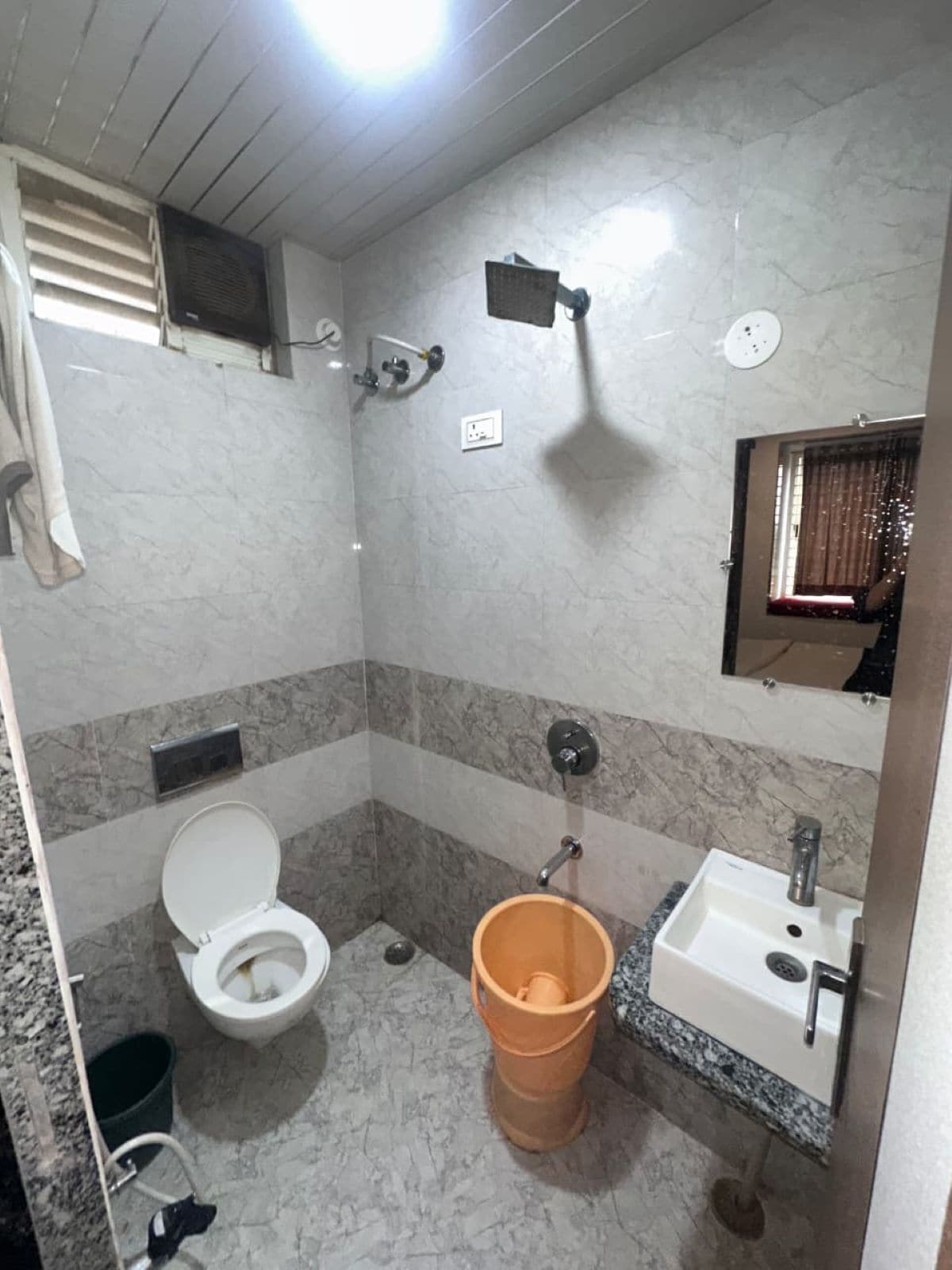 A bathroom with a toilet, sink, and shower.