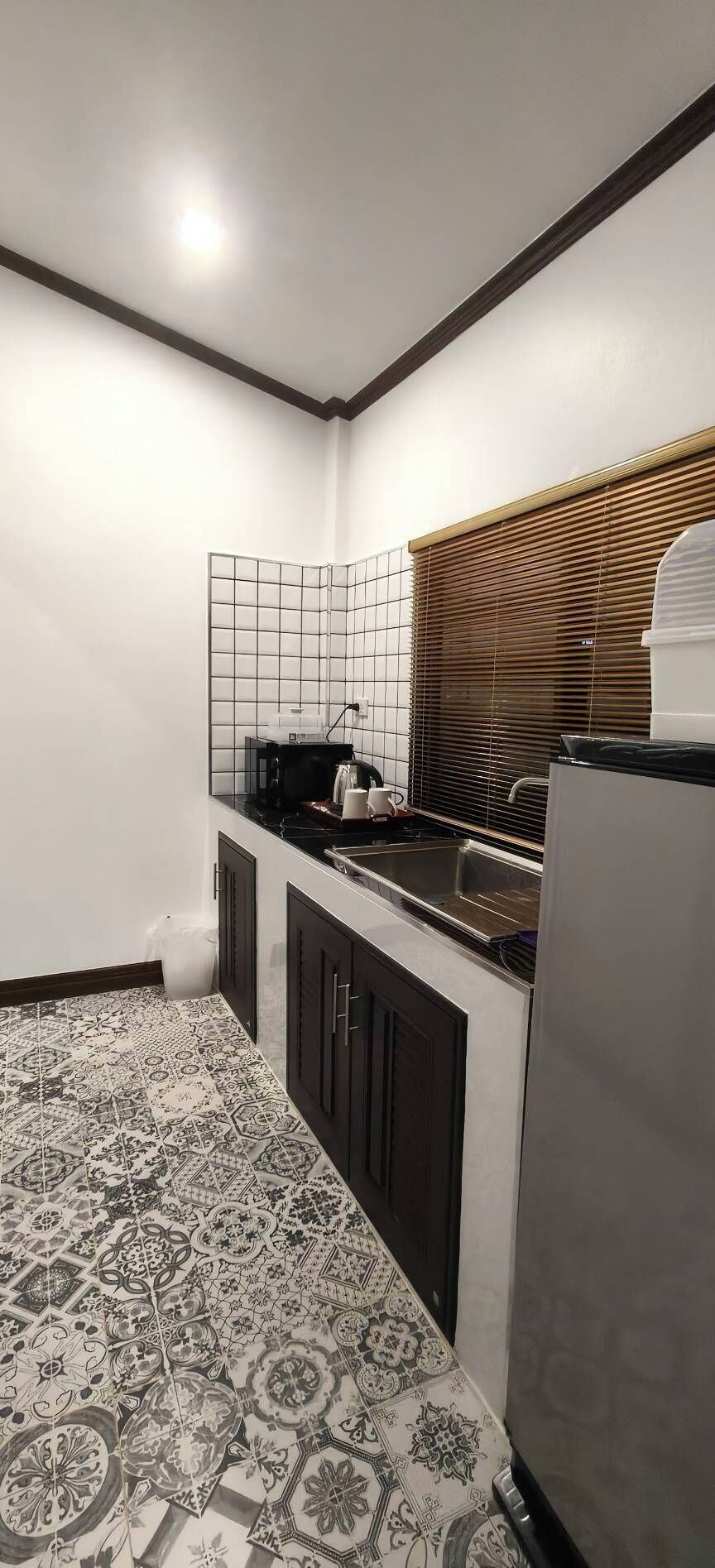A compact kitchen with a built-in microwave, a sink, and a refrigerator.