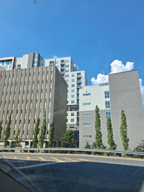 Ein modernes Gebäude mit einer markanten Fassade, umgeben von Grün und einem klaren Himmel.