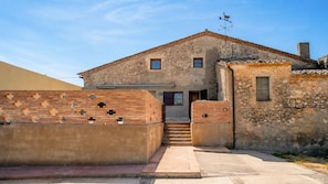 Un edificio rústico de fachada de piedra, puerta de madera y una ventana pequeña.