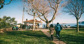 A park with a gazebo, a pathway, and a body of water in the background. - Aurrekoetxea 36 Vacation Rental Tala 10 (Bermeo)