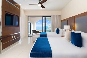 A hotel room with a large bed, a TV, a ceiling fan, and a view of the sea. - Escape to a beautiful two-bedroom oceanfront resort in Cabo. (San José del Cabo)