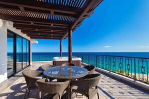 A covered outdoor seating area with a view of the ocean. - Escape to a beautiful two-bedroom oceanfront resort in Cabo. (San José del Cabo)