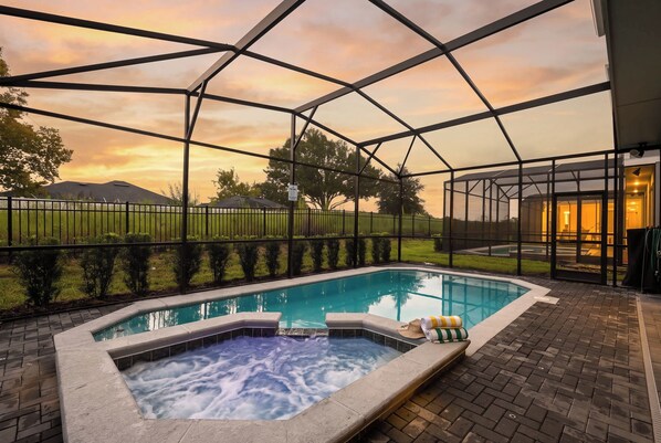 Una piscina con jacuzzi, rodeada por un área de terraza cubierta.