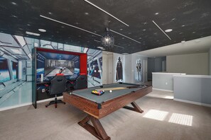 A room with a pool table, a gaming chair, and a Star Wars-themed wall. - Themed 7BR by Disney | Heated Pool + Game Room (Davenport)