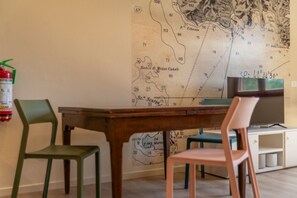 A room with a map on the wall, a wooden table, and two chairs. - APPARTAMENTI IL SENTIERO DEL GRANITO - GRANITO BILO 1 DX (Campo nell'Elba)