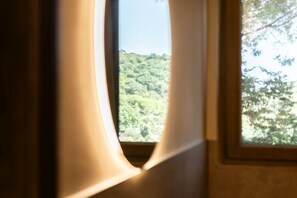 Ein Fenster mit Blick auf eine bewaldete Landschaft.