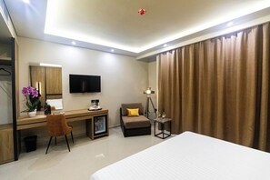 A hotel room with a bed, desk, chair, television, and curtains. - Kraal Hotel Vlore (Vlorë)