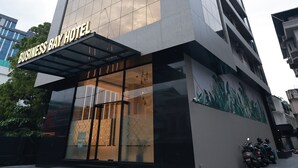 A modern hotel building with a glass facade and a sign that reads 'Business Bay Hotel'.