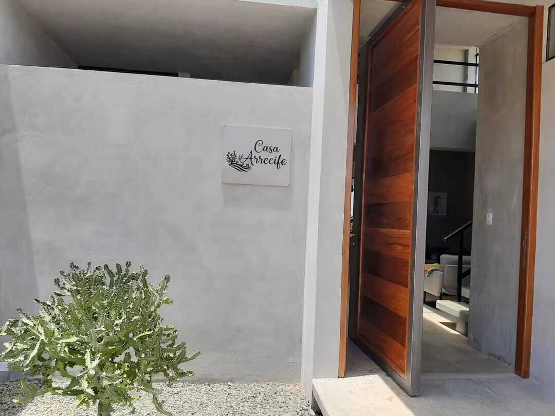 A building entrance with a sign reading 'Casa Arrecife' and a wooden door.