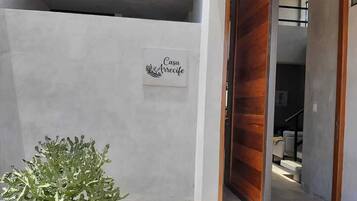 A building entrance with a sign reading 'Casa Arrecife' and a wooden door.
