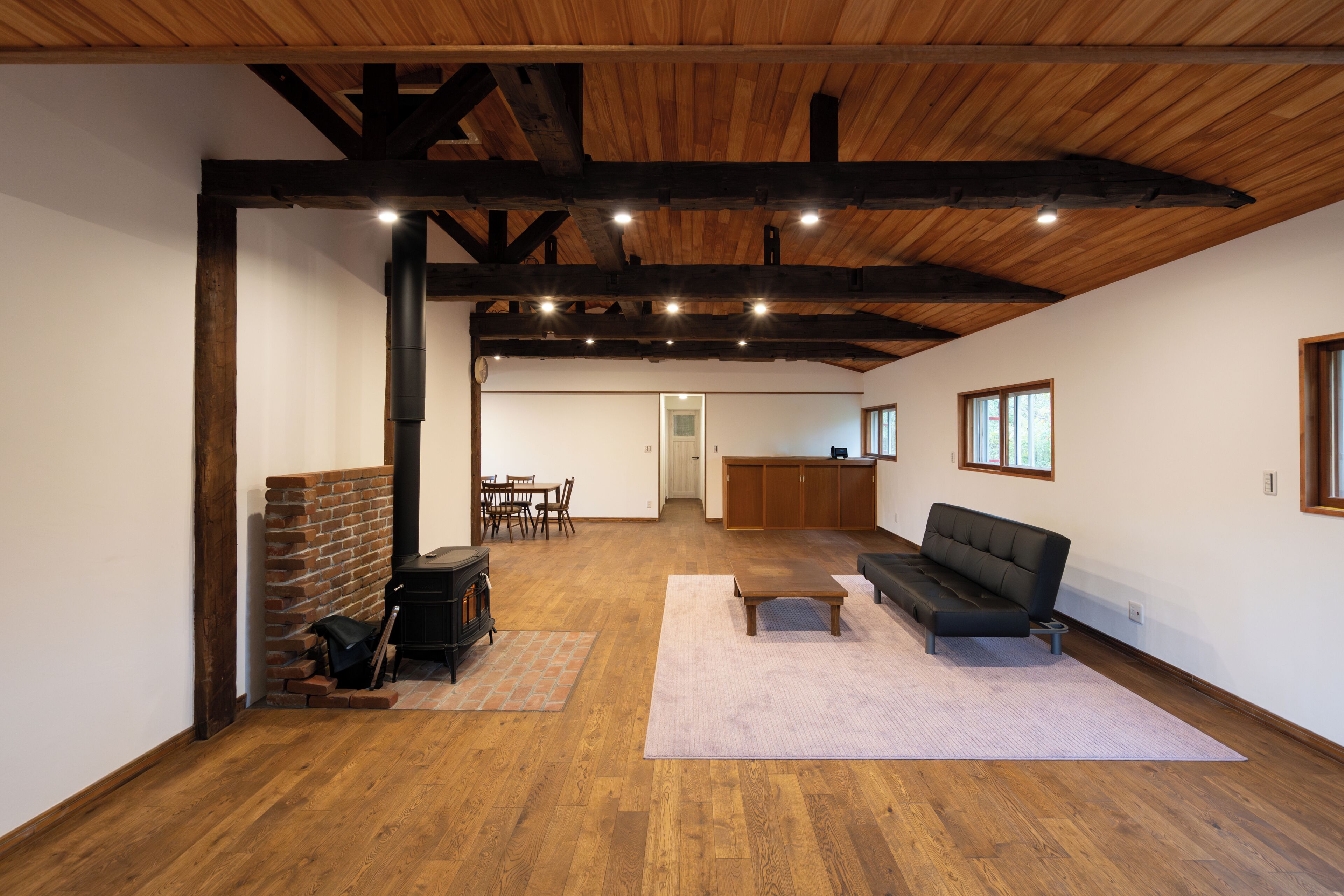 A spacious living area with a fireplace, a sofa, and a dining table.