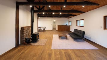 A spacious living area with a fireplace, a sofa, and a dining table.