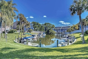 A marina with boats docked, surrounded by palm trees and a grassy area. - Renovated Condo Across from Siesta Key Beach | (Siesta Key)