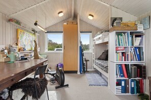 A compact room with a wooden ceiling, a desk with a chair, a bookshelf, a bunk bed, and a window. - Cozy house by Klitgård Fishing Village (Nibe)