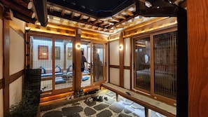 Ein traditioneller japanischer Raum mit Tatami-Boden, Schiebetüren und einer Holzdeckenkonstruktion.