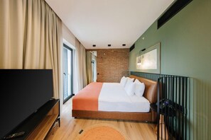 A hotel room with a bed, a TV, a brick wall, and a window. - Hotel 21, Tbilisi (Tbilisi)