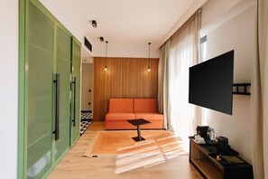 A modern living room with a sofa, a coffee table, and a flat-screen TV. - Hotel 21, Tbilisi (Tbilisi)