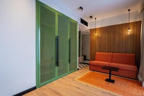 Un interior moderno con un sofá, una mesita y una zona delimitada en verde.