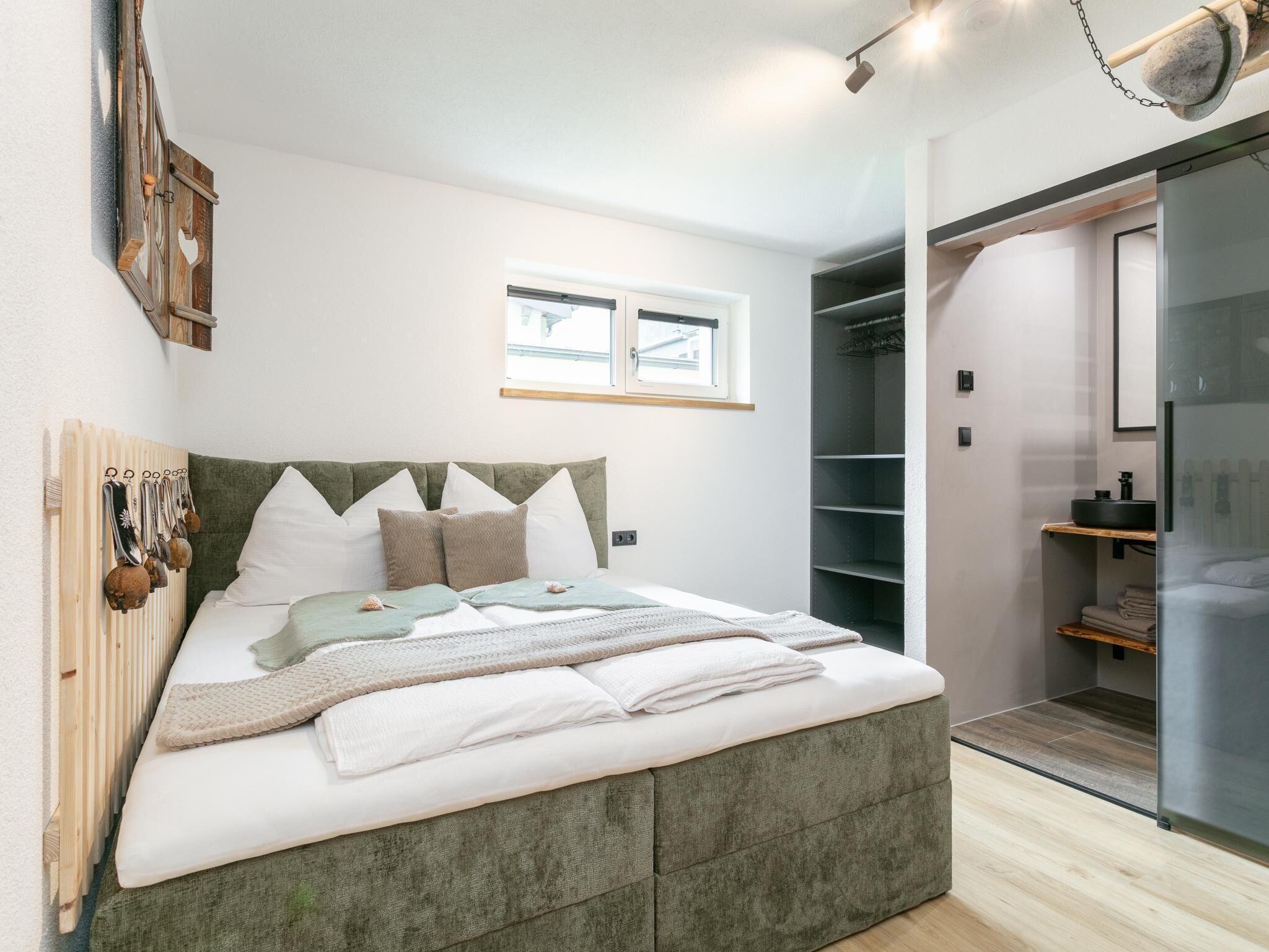 A modern bedroom with a bed, a wardrobe, and a bathroom.