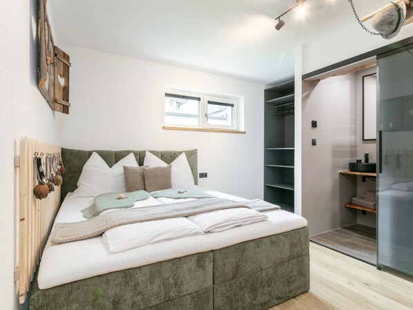 Une chambre à coucher moderne, équipée d’un lit, d’une armoire et d’une salle de bain.