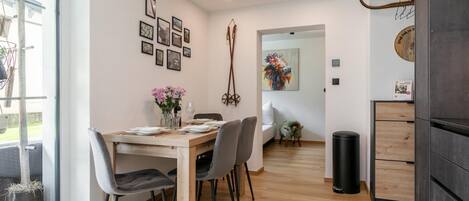 Een moderne eethoek met een houten tafel, stoelen en een bloevas.