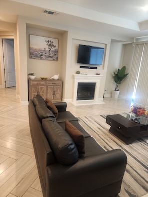 A living room with a sofa, a fireplace, a television, and a potted plant. - Fantastic 4-bedroom house with AC in cool Bay Point (Bay point)