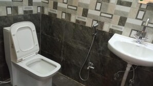 Un baño con inodoro, ducha y lavamanos.