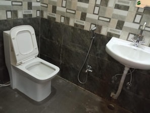 Un baño con inodoro, ducha y lavamanos.