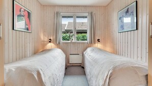 A room with two single beds, a window with curtains, and two wall-mounted lamps. - Stunning Sea Views, Wood-Fired Hot Tub & Nature (Haarby)