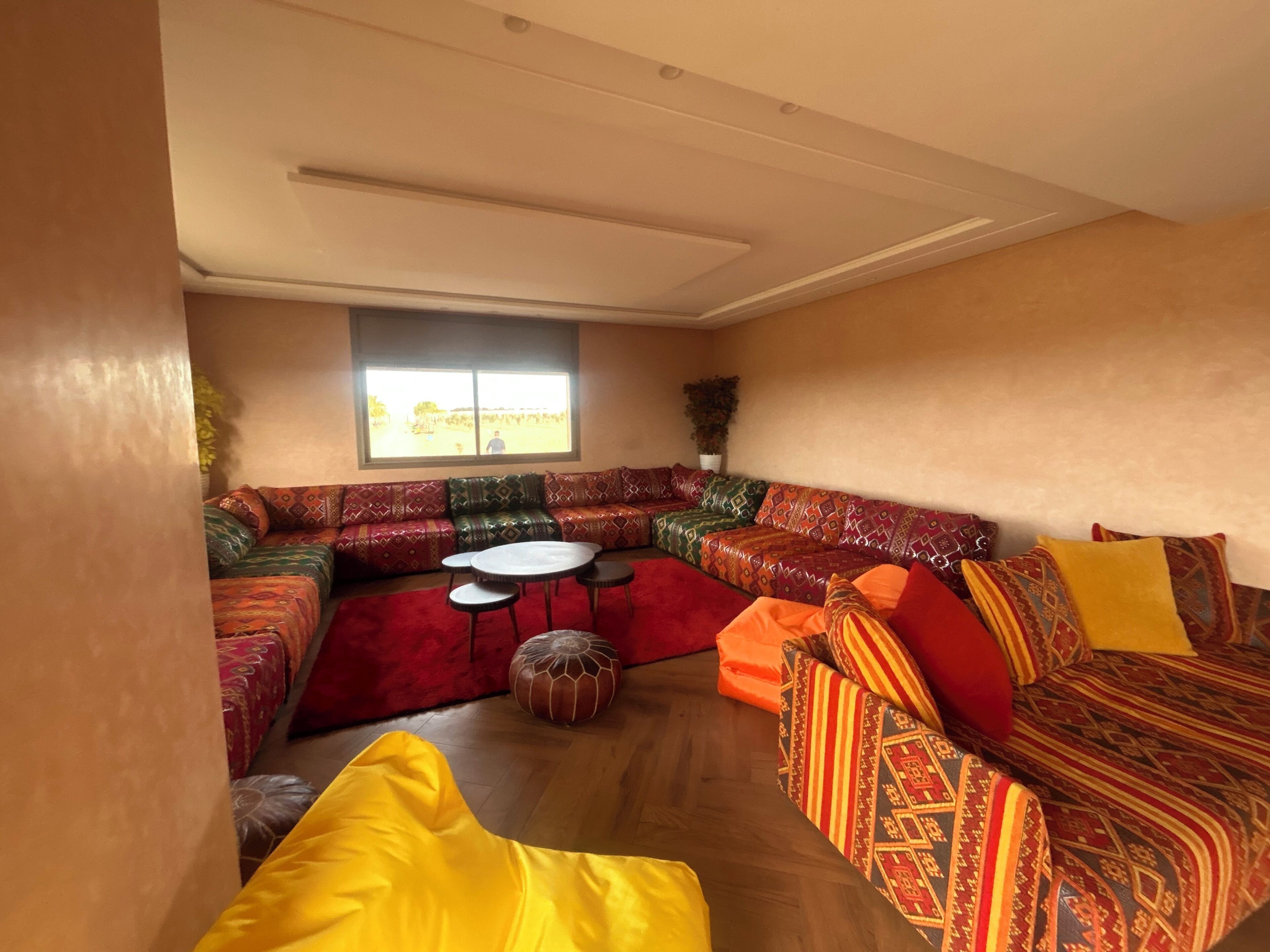 Ein geräumiges Wohnzimmer mit einer großen Eckcouch, einem Couchtisch und einem kleinen runden Tisch.