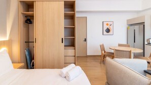 A hotel room with a bed, a wardrobe, a dining table with chairs, and a kitchenette. - Myla - Loft LowF Near Centro Historico (Mexico City)