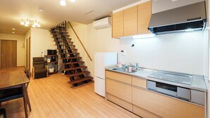 A modern kitchen with wooden cabinets, a built-in stove, and a stainless steel sink.