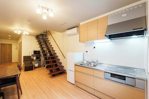 A modern kitchen with wooden cabinets, a built-in stove, and a stainless steel sink.