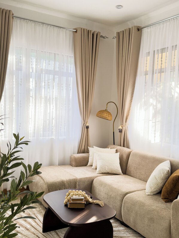 A modern living room with a beige sofa, a small coffee table, and a floor lamp.