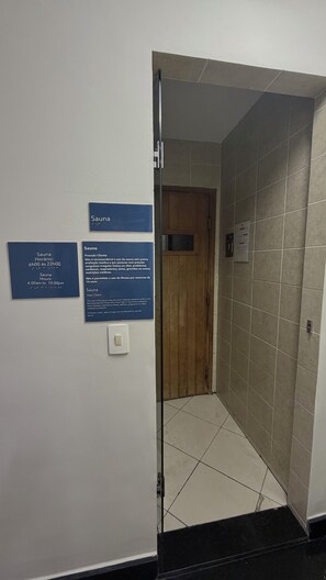 Een gang met een sauna-bordje en een deur naar het sauna-gedeelte.