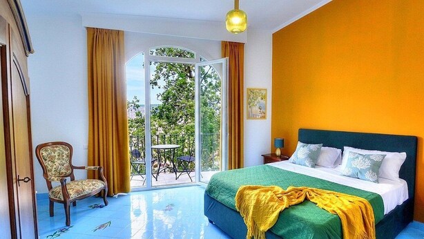 Un dormitorio con cama, una silla, una mesa y vistas al exterior.
