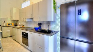 Una cocina con un refrigerador de acero inoxidable, un microondas y un lavamanos.