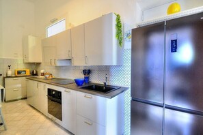 A kitchen with a stainless steel refrigerator, a microwave, and a sink. - Villa Talassia: A charming two-story villa built sheer above the sea and with direct access to the sea, with Free WI-FI. (Massa Lubrense)