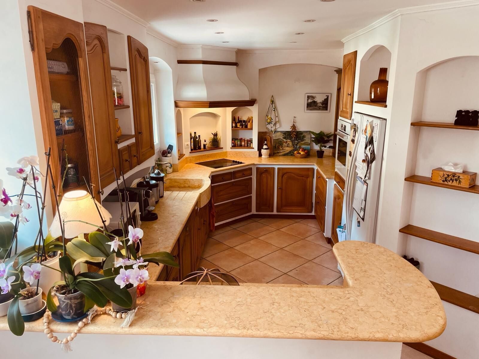 A kitchen with wooden cabinets, a built-in stove, and a tiled backsplash.