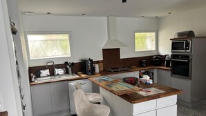 A compact kitchen with a central island, a built-in oven, and a microwave.