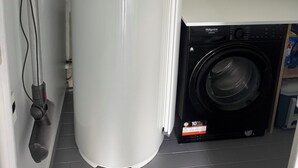 A compact kitchen with a built-in washing machine and a water heater.