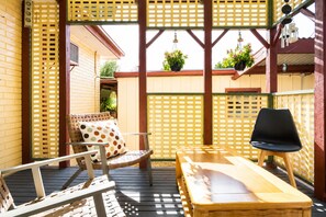 A wooden deck with a table and chairs, a bench, and a lattice fence.