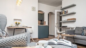 Moderni olohuone, jossa on sohva, sohvapöytä ja kirjahylly.